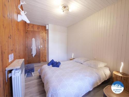 a bedroom with a bed with a blue bow on it at "La bâtisse des prés" in Puy-Saint-Vincent