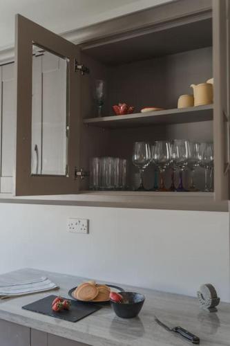 a kitchen with a counter with glasses on a shelf at Elena Retreats in Drogheda