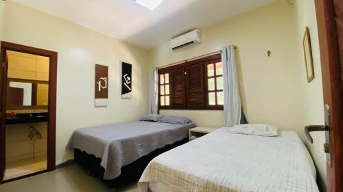 a bedroom with two beds and a window at CasaMares Macapá - Praia de Macapá in Macapá