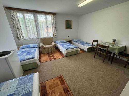 Habitación con 4 camas, mesa y mesa. en Ubytovna Český Krumlov, en Český Krumlov