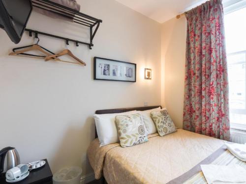 a small bedroom with a bed and a window at Notting Hill Gate Hotel in London