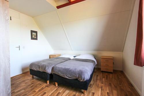 una camera da letto con un letto in una stanza di KG - Vakantiewoning 11 a Opperdoes