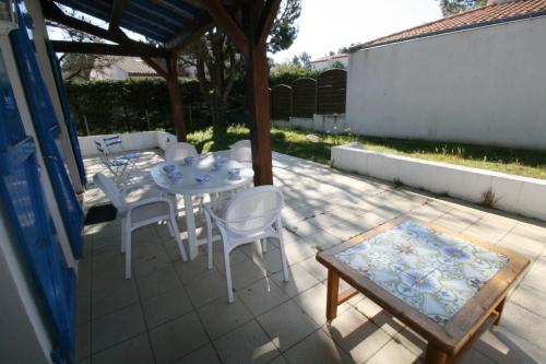 d'une terrasse avec une table, des chaises et un kiosque. dans l'établissement Maison dans les pins, à La Tranche-sur-Mer