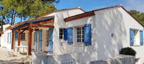 Maison blanche avec volets bleus dans l'établissement Maison dans les pins, à La Tranche-sur-Mer