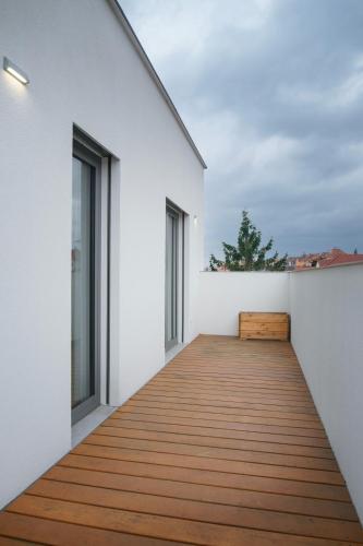 a wooden boardwalk leads to the balcony of a house at Apartments Poděbradova Premium in Brno