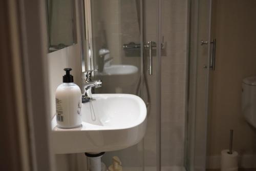 a bathroom sink with a bottle of soap on it at Estudio Veintisiete in Morón de la Frontera