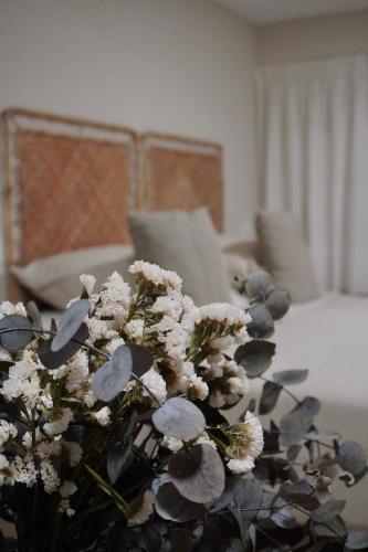 a vase of flowers on a table in a room at Estudio Veintisiete in Morón de la Frontera