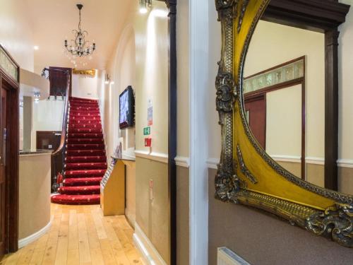 a mirror on the wall of a hallway with a staircase at Notting Hill Gate Hotel in London