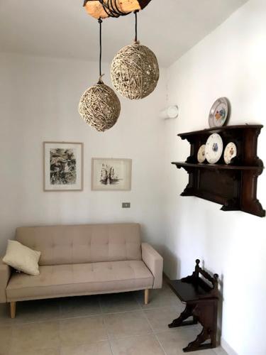 a living room with a couch and two hanging lights at Masseria Scianne in Sant'Isidoro