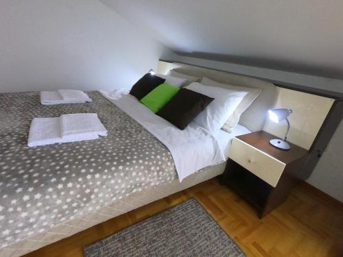 a bedroom with a large bed with a green pillow at Apartman ZENIT in Vrnjačka Banja