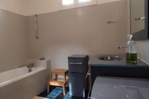 une salle de bain avec un lavabo et une baignoire et un lavabo dans l'établissement Maison Domin'O 10 pers, à Les Sables Vignier