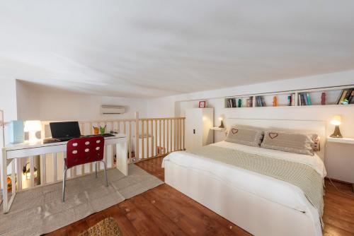 una camera da letto con un letto e una scrivania con una televisione di Bartolommeo Scala Loft by Mmega a Firenze