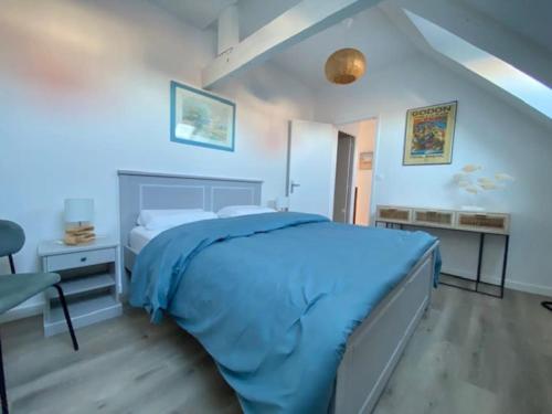 - une chambre avec un lit bleu et un bureau dans l'établissement La Capitainerie Beau duplex face port de plaisance, à Étaples