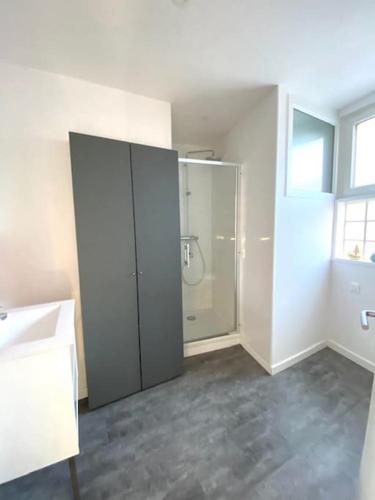 une salle de bain blanche avec une douche et un lavabo dans l'établissement La Capitainerie Beau duplex face port de plaisance, à Étaples