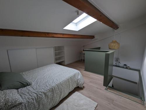 une chambre avec un lit et une lucarne dans l'établissement Duplex des Volcans, à Le Cendre