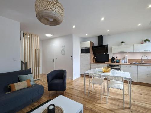 un salon avec un canapé et une table et une cuisine dans l'établissement Duplex des Volcans, à Le Cendre