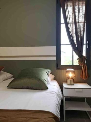 - une chambre avec un lit doté d'une fenêtre et d'une lampe dans l'établissement T2 Coeur village basque, avec terrasse, Artzamendi, à Larressore