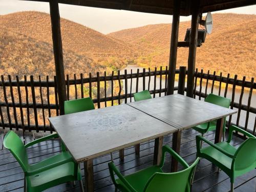 a table and chairs on a porch with a view at Livingstone Bush Lodge, Mabalingwe in Bela-Bela