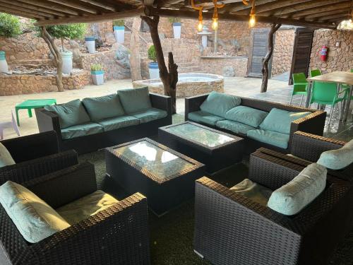an outdoor patio with couches and a table and chairs at Livingstone Bush Lodge, Mabalingwe in Bela-Bela