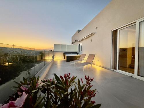 a balcony of a house with a table and chairs at C'est La Vie Boutik Swieqi in Is-Swieqi