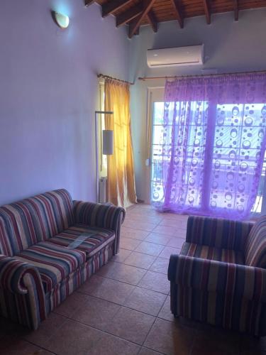 a living room with two couches and a window at Μεζονέτα AIKATERINI N 7 in Chios