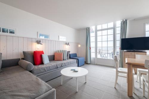 a living room with a couch and a table at Pierre & Vacances Premium Résidence de la Plage in Le Crotoy