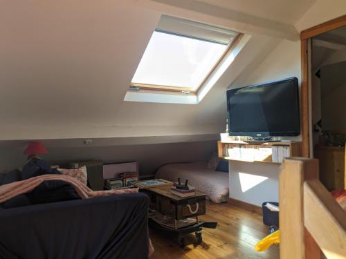 ein Wohnzimmer mit einem großen Fenster und einem TV in der Unterkunft Les Vieilles Aitres in Sargé Les Le Mans 