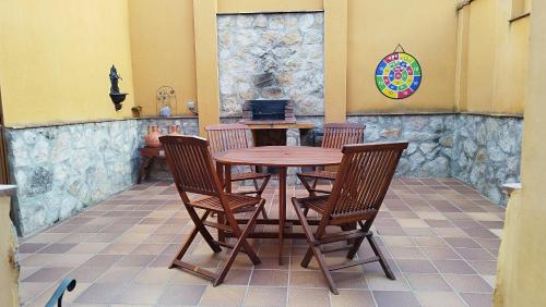 una mesa de madera y 4 sillas en un patio en Casa Rural El Abuelo Anselmo en Segovia