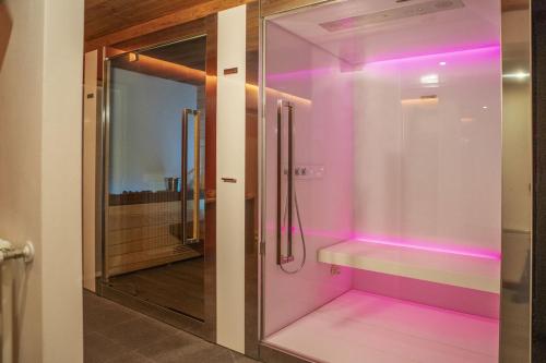 a bathroom with a shower with pink lighting at Ca' del Sole in San Vito di Cadore