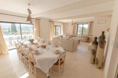 d'une salle à manger avec une grande table et des nappes blanches. dans l'établissement La Bastide d'EAU - Exceptionnel, 5 Stars, 14 pers., à Saint-Cyr-sur-Mer