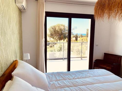 um quarto com uma cama e uma grande janela em Villa Livia Porticcio piscine 500m plage em Porticcio