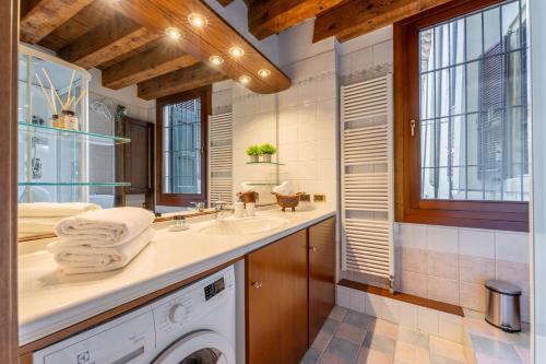 a bathroom with a sink and a washing machine at Sgarzerie Luxury Flat 2 rooms 120mq in Verona