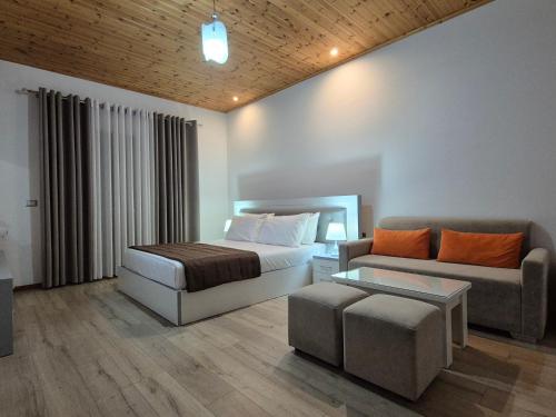 a bedroom with a bed and a couch at ORCHIDS Hotel in Sarandë