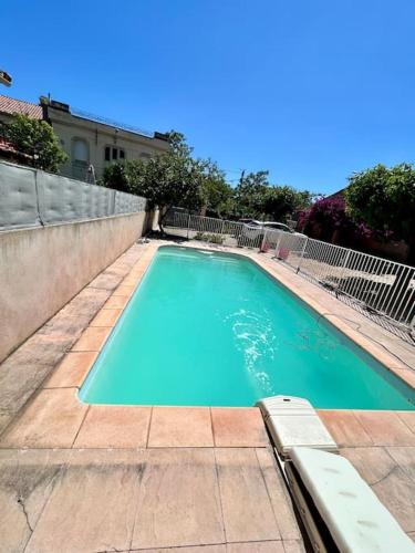une piscine avec de l'eau bleue devant un immeuble dans l'établissement Juchanie YourHostHelper, à Toulon
