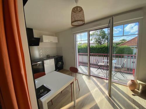 une petite cuisine avec une table et une vue sur un balcon dans l'établissement Appartement en centre-ville, à La Teste-de-Buch