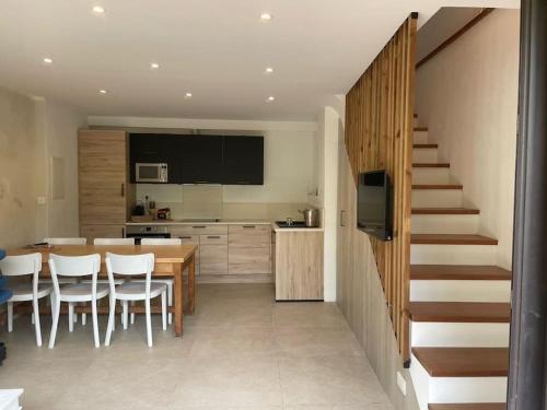 une cuisine avec une table et des chaises ainsi qu'un escalier dans l'établissement Maison Béatrice, mignonne, rénové avec terrasse et jardin, près de village, à La Garde-Freinet