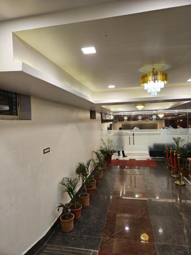a lobby with potted plants and a chandelier at HOTEL MAA LAXMI PALACE in Deoghar
