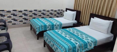 a hotel room with two beds in a room at Hotel Royal Vista in Karachi