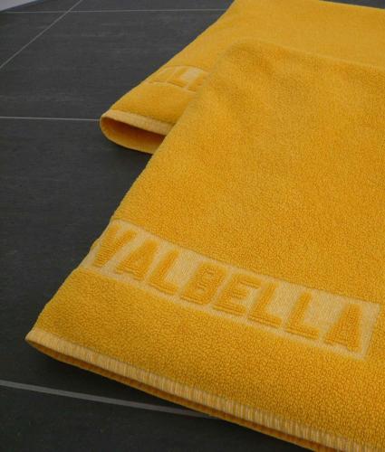 two yellow towels sitting on top of a table at Valbella Bed & Breakfast in Partenen