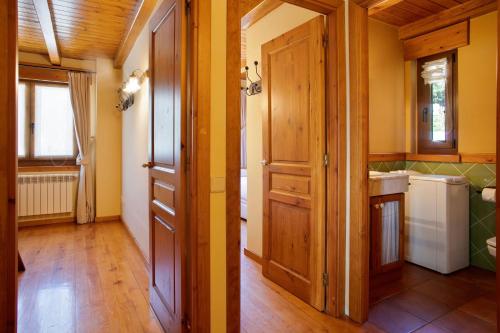 cocina con paredes de madera, suelo de madera y puerta en Luderna - Apartamento Dera Pincèla, en Vielha