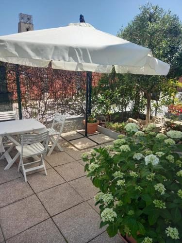 a table and chairs under an umbrella on a patio at La Casa di Piccolì di Gabriele Martelli e Catia Pacetti - APPARTAMENTO in Ancona