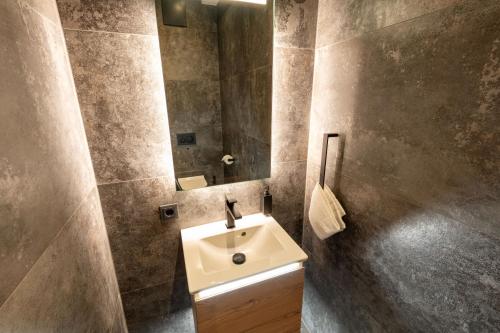 a bathroom with a sink and a mirror at Penthouse Bergseetraum mit 102 qm Dachterrasse in Walchsee