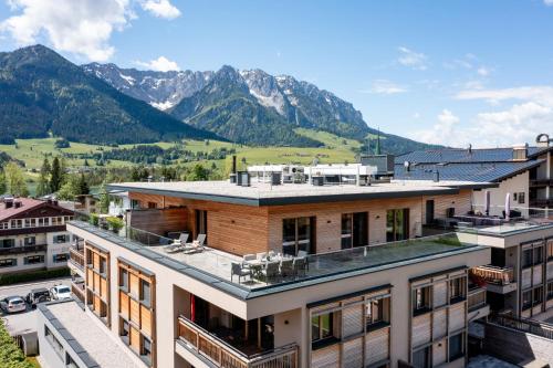 a view of a building with mountains in the background at Penthouse Bergseetraum mit 102 qm Dachterrasse in Walchsee