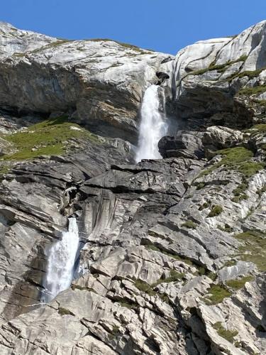 a waterfall on the side of a rocky mountain at Apartment im Stenna Vallada direkt bei den Bergbahnen in Flims