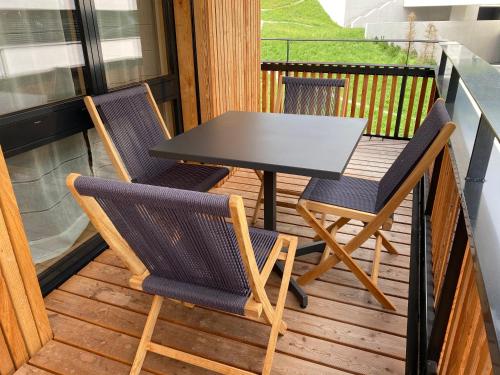 a table and two chairs on a balcony at Apartment im Stenna Vallada direkt bei den Bergbahnen in Flims