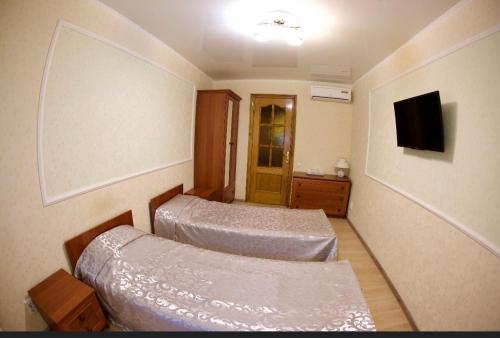 a hotel room with two beds and a tv at Vilari Odessa in Odesa
