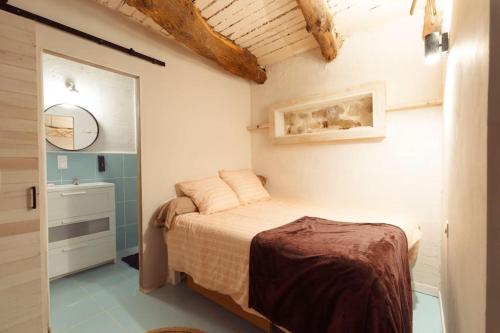 une petite chambre avec un lit et un miroir dans l'établissement Studio provençal au cœur de la Sainte-Victoire, à Puyloubier