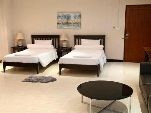a living room with two beds and a coffee table at P.K. Garden Home in Bangkok