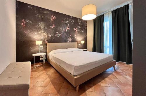 Un dormitorio con una cama y una pared con flores. en Le Quiete Stanze, tra le colline e il mare, posto spiaggia e auto incluso, en Numana