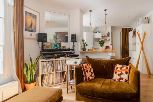 un salon avec un canapé et quelques disques dans l'établissement Paris Porte Maillot Design Residence, à Neuilly-sur-Seine